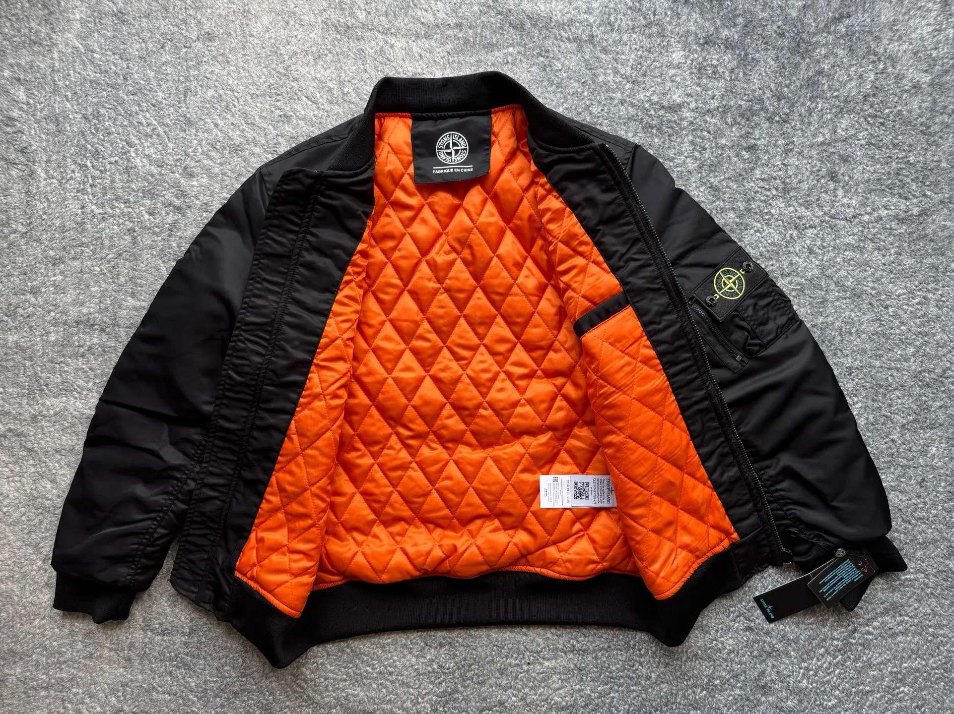 P360 Stone lsland Stone Island Medal Aviator Cotton Jacket The outer fabric is made of MA-1 flight nylon, which is a material specially used in flight and aviation. Flying nylon is a fabric specially used in flight and aviation. It is rarely used in ordinary clothing. The density of flying nylon is very high, so it is windproof and waterproof. When rain falls on the surface of the clothes, it will not penetrate immediately, but will form a small water droplet and slide off. This performance is a requirement for the development of modern jet technology. Because it is assumed that the pilot got caught in the rain before getting on the plane, he entered the cabin covered in rainwater. When flying at high altitude and at high speed, in a cabin without an environmental control system, water droplets will freeze on the pilot's body 2. Knitted baseball collar MA-1 uses a knitted collar. The collar is made of wool and can be snug around the neck and very warm. 3. Metal zippers We have very strict requirements on zippers, including smoothness and size. There was no zipper on the market that met the requirements, so we asked a zipper factory to customize a strong and durable metal zipper.  4. Double-threaded knitted cuffs The cuffs are made of double-threaded knitted fabric, narrow at the front and wide at the back. The narrow part can be tightened around the wrist to prevent wind from entering. The wide part has enough space when wearing multiple pieces under winter Color: Black Dark Army Green Size: M L.